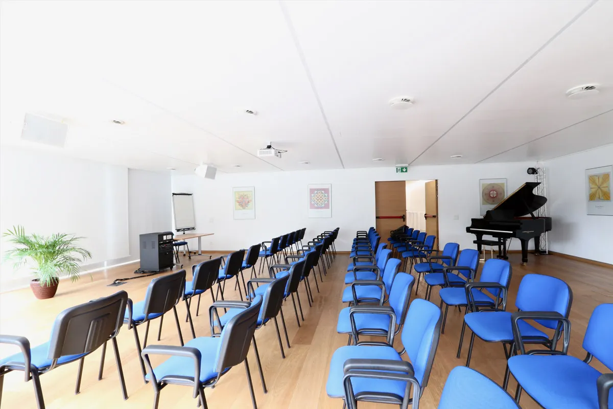 Sala Girasole allestita a platea con sedie blu e pianoforte a coda